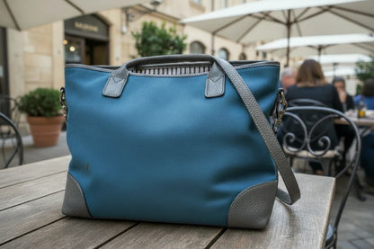 Blue bag with gray accents on a wooden table outdoors