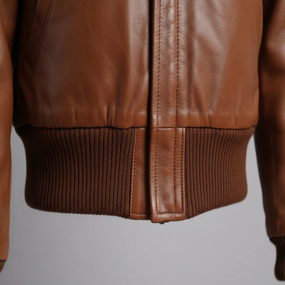 Close-up of a brown leather jacket on a gray background