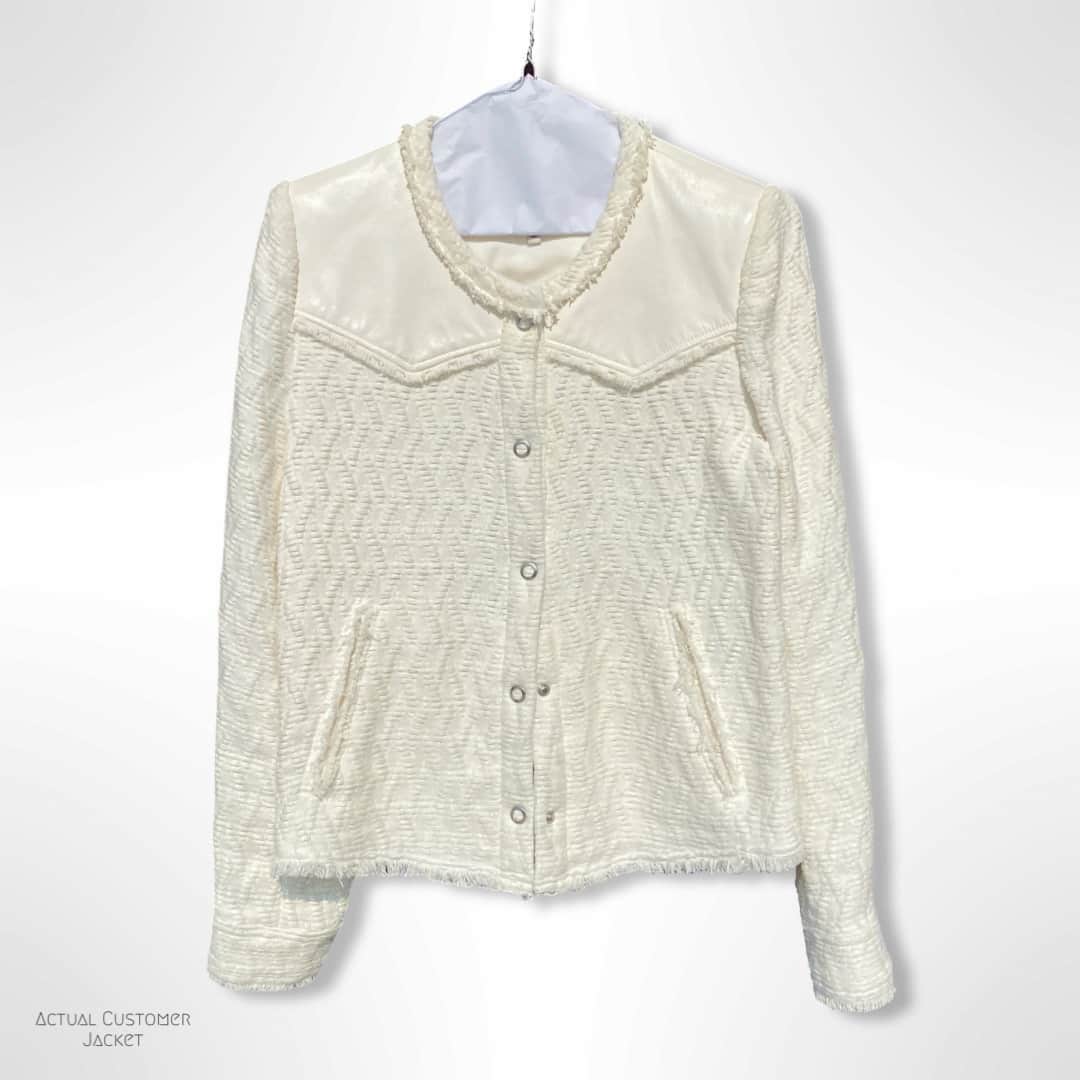 White textured jacket on a hanger against a white background