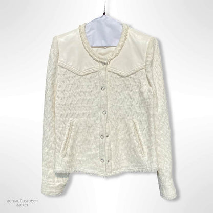 White textured jacket on a hanger against a white background